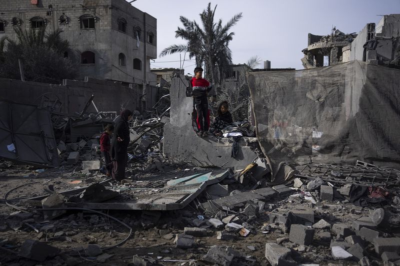 Palestinians inspect the damage to residential buildings in Rafah, southern Gaza Strip.